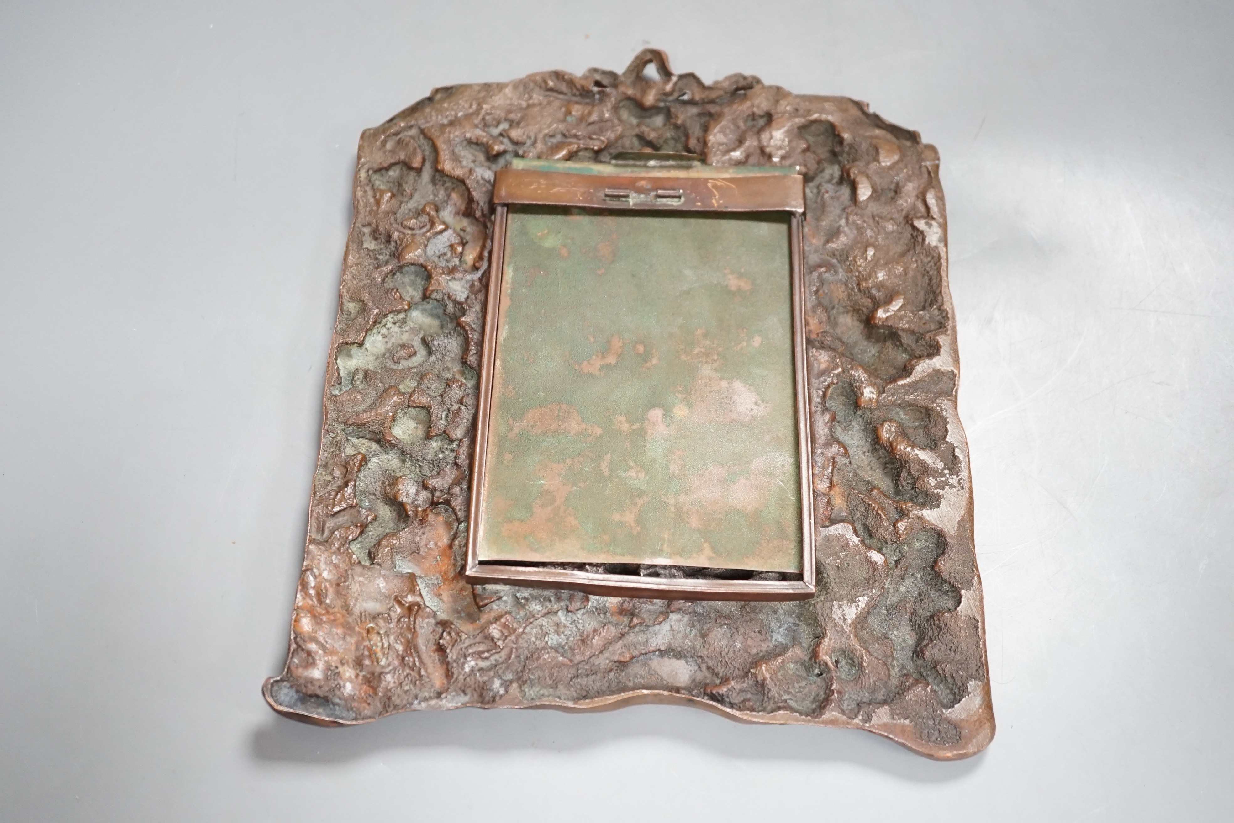 A bronzed copper frame decorated with putti, circa 1900. 28.5cm long